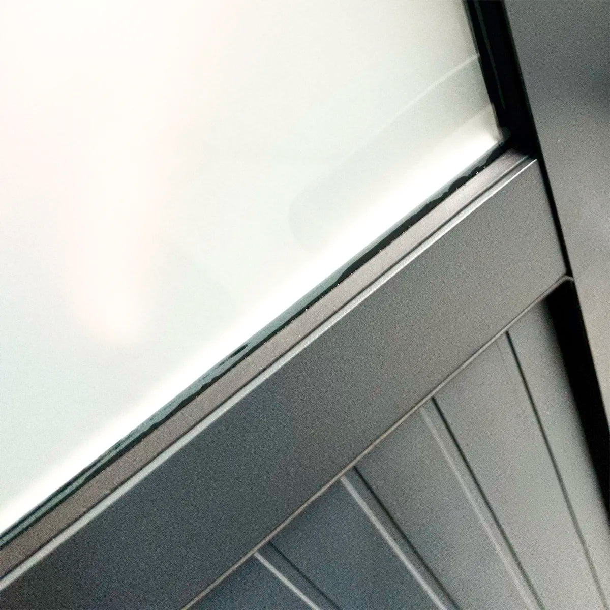 Angle du cadre aluminium et vitrage dépoli de la porte Mira