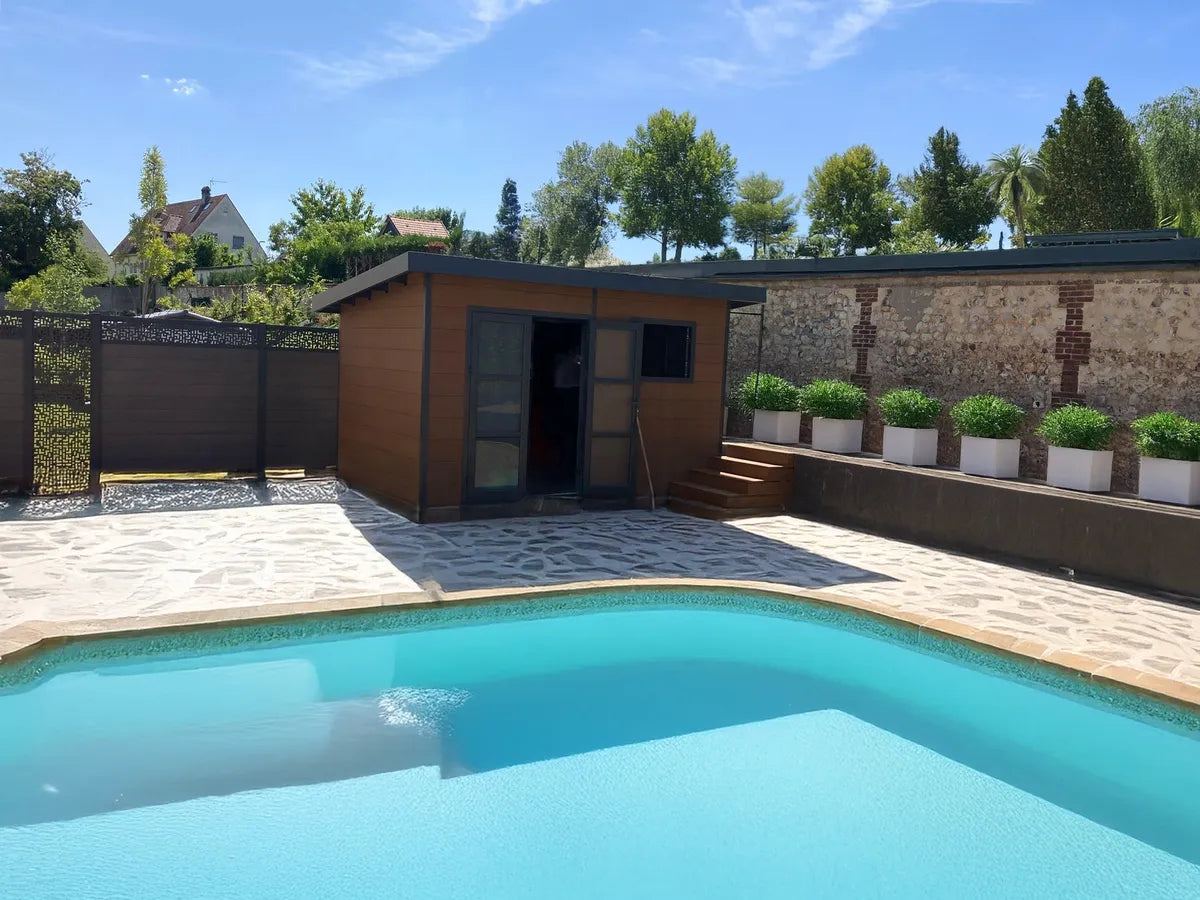 Abri composite brun installé chez un client au fond d'une piscine