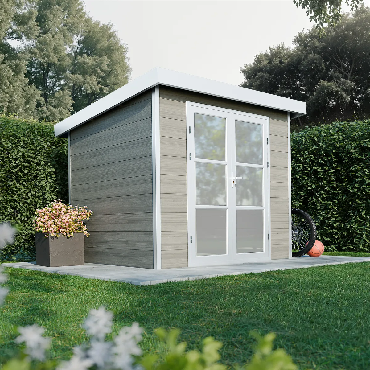 Abri de jardin composite Alma 5 m² avec toit plat en ambiance jardin