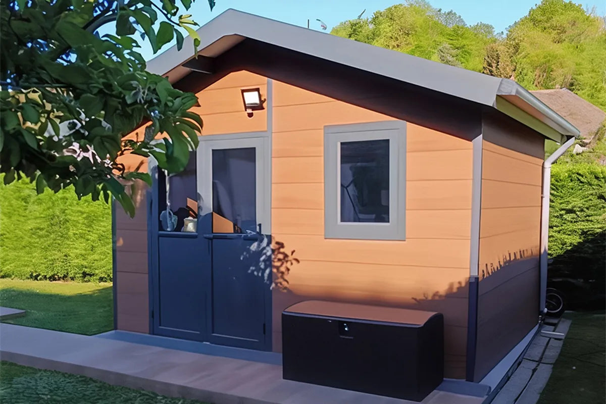 Abri composite Isora brun à fenêtres, installé chez un client avec coffre de rangement