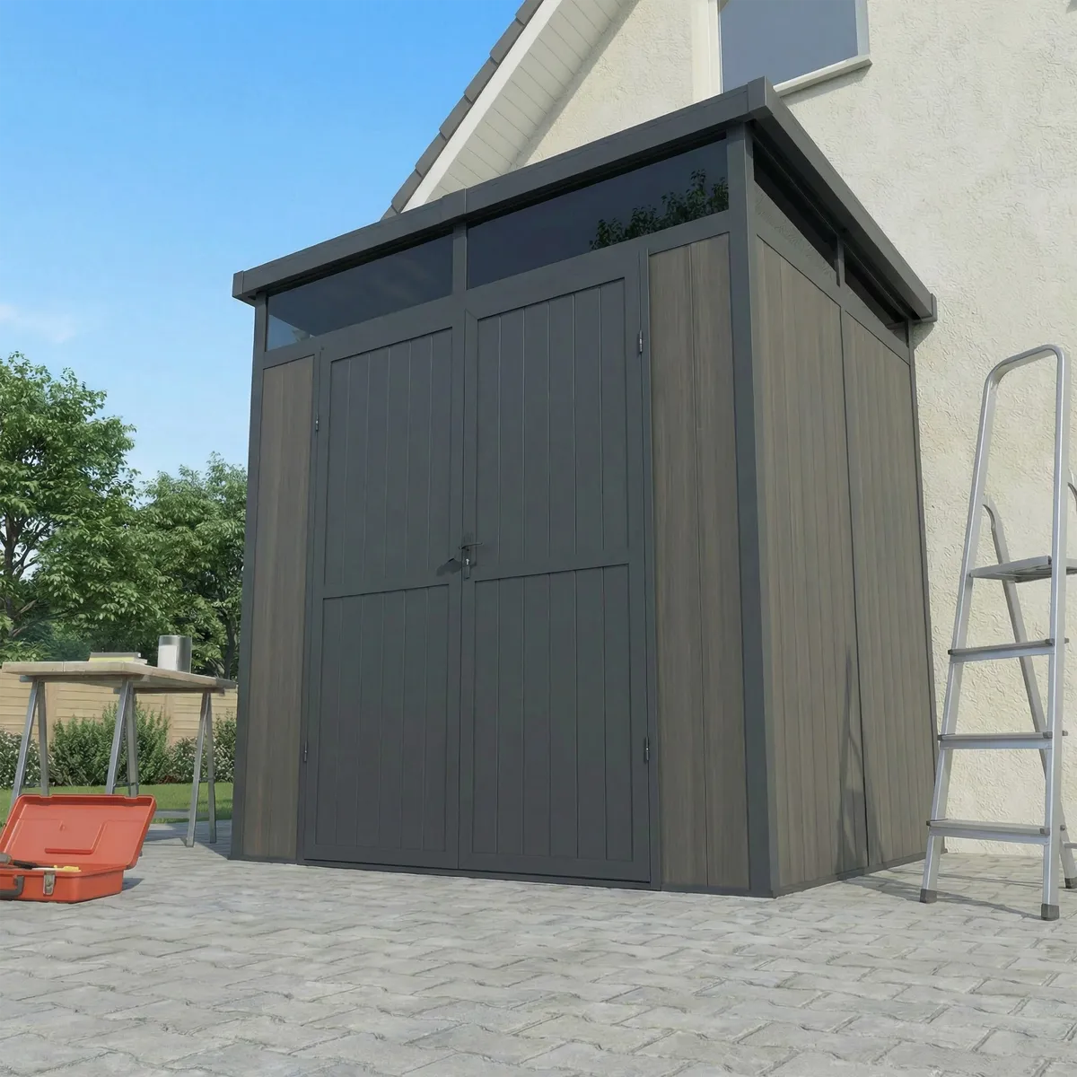Abri composite Evora 4 m² gris adossé à une maison, sur pavés